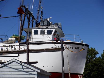 close-up side view of a red-and-white fishing boat, the Seaman's Toy 1, in drydock in Annapolis Royal, Nova Scotia.  Bordered Page size 3000 x 2250px (300ppi), prints at 10 x 7.5".